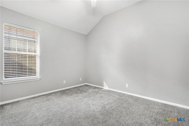 unfurnished room featuring carpet floors and vaulted ceiling