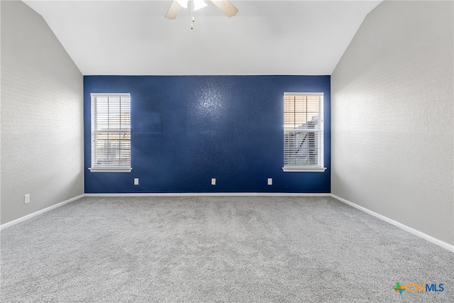 carpeted empty room with ceiling fan and lofted ceiling