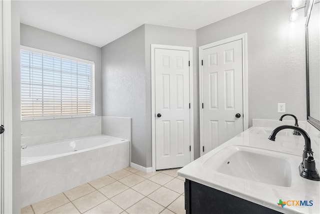 bathroom with tile patterned flooring, vanity, and a washtub