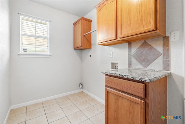 clothes washing area with cabinets, hookup for a washing machine, light tile patterned floors, and electric dryer hookup