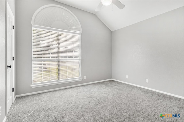 carpeted spare room featuring ceiling fan and lofted ceiling