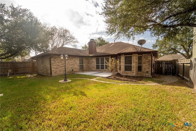 back of property with a lawn and a patio