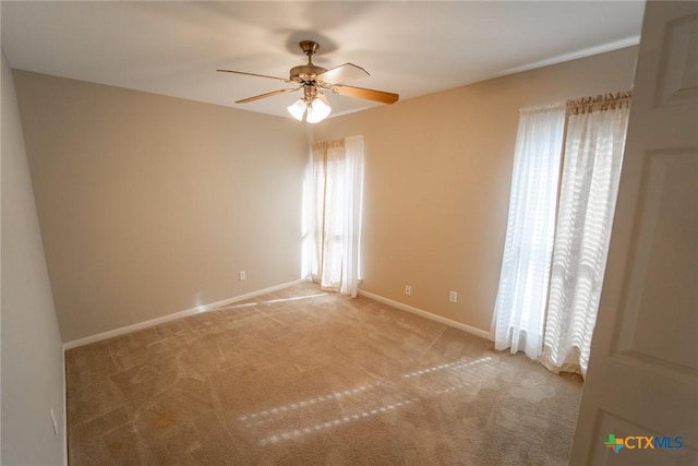 empty room with carpet floors, plenty of natural light, and ceiling fan