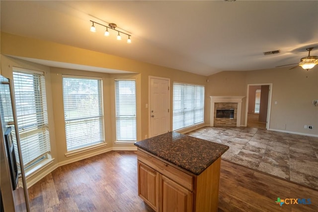 206 Ashland Crk, Victoria, TX 77901 - kitchen with a glass covered fireplace, ceiling fan, open floor plan, wood finished floors, and vaulted ceiling