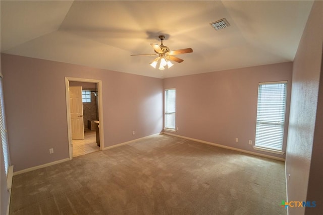 empty room with light carpet, ceiling fan, and vaulted ceiling