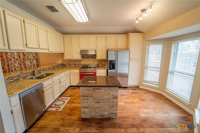 206 Ashland Crk, Victoria, TX 77901 - kitchen featuring stainless steel appliances, vaulted ceiling, backsplash, stone counters, and a kitchen island