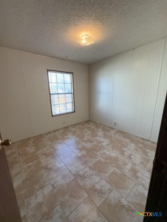 spare room with a textured ceiling