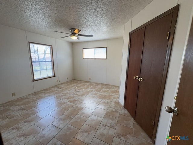 unfurnished bedroom featuring ceiling fan and a textured ceiling