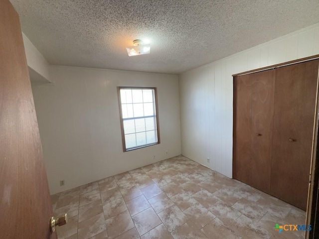 unfurnished bedroom with a textured ceiling and a closet