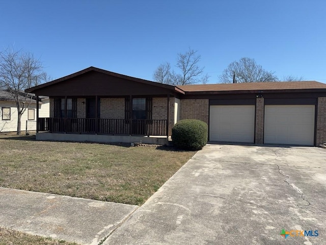 view of front facade with an attached garage, a front yard, concrete driveway, and brick siding