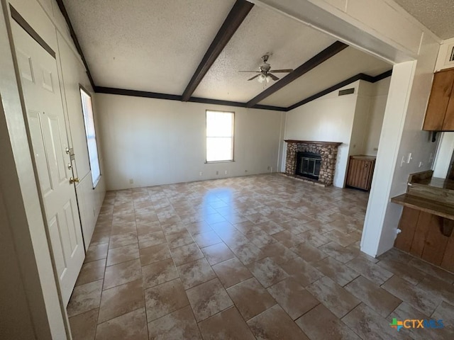 unfurnished living room with a ceiling fan, a brick fireplace, a textured ceiling, and lofted ceiling with beams