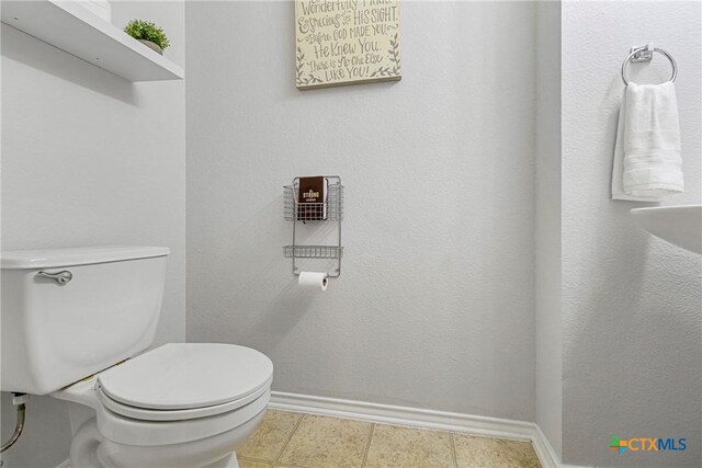 bathroom featuring toilet and baseboards