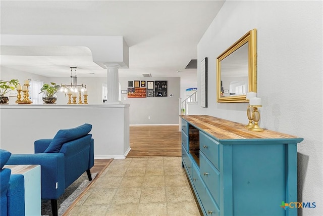 interior space featuring baseboards, decorative columns, visible vents, and a wealth of natural light