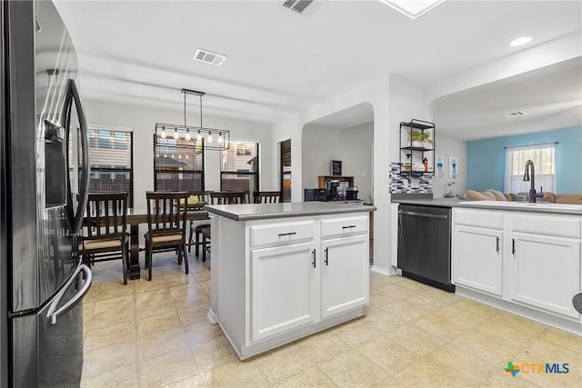 kitchen featuring dishwasher, stainless steel refrigerator with ice dispenser, white cabinetry, and visible vents