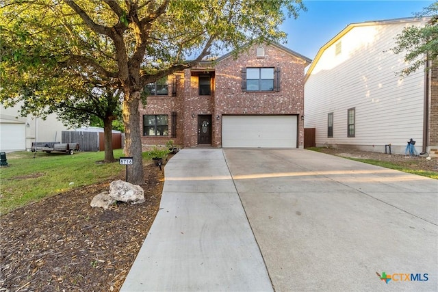 traditional-style home with brick siding, fence, driveway, a front yard, and an attached garage