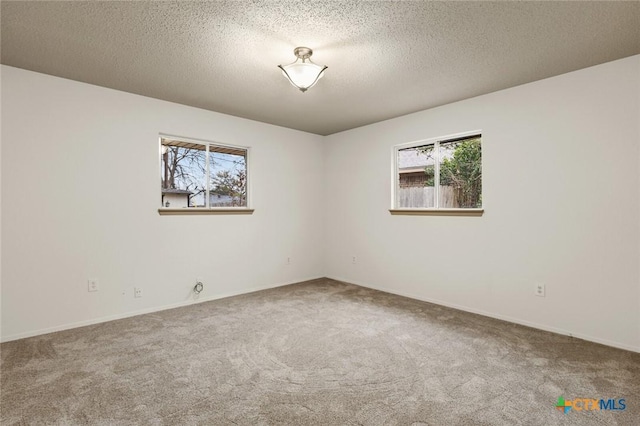 spare room featuring carpet floors and a textured ceiling