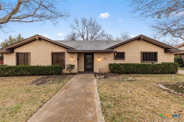 ranch-style house with brick siding and a front yard