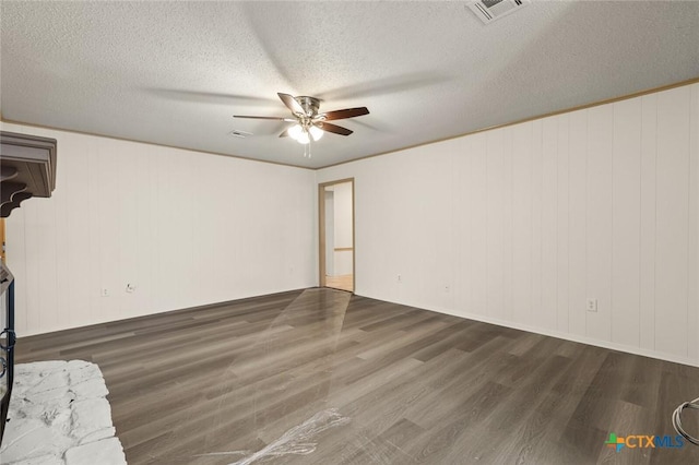 unfurnished room featuring a ceiling fan, a textured ceiling, visible vents, and wood finished floors