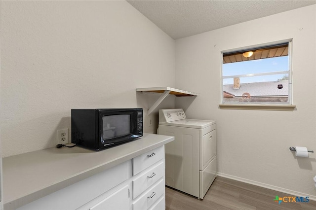 laundry room with a textured ceiling, laundry area, baseboards, light wood-style floors, and washer / dryer