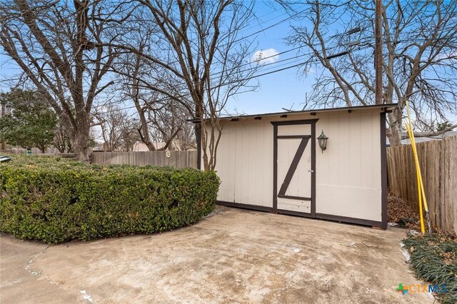 view of shed featuring fence