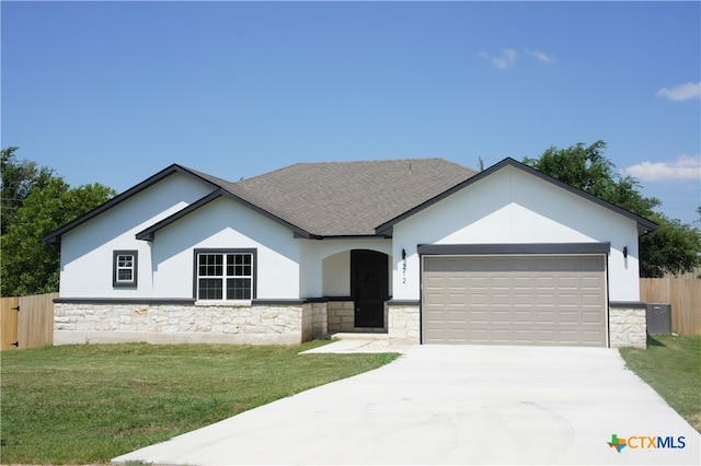 view of front of house featuring a garage and a front lawn