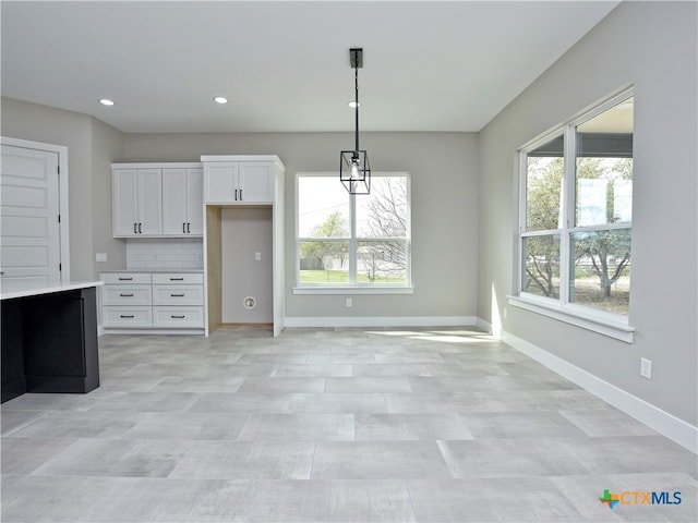 kitchen featuring white cabinetry, pendant lighting, and decorative backsplash