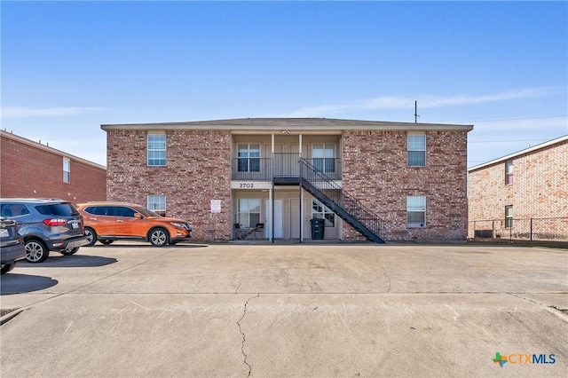 view of building exterior featuring uncovered parking and stairway