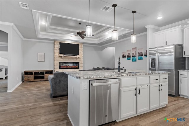730 Eagle Pass Dr, Salado, TX 76571 - kitchen featuring hanging light fixtures, stainless steel appliances, an island with sink, sink, and white cabinetry