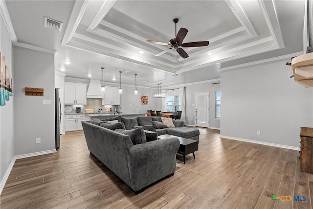 730 Eagle Pass Dr, Salado, TX 76571 - living room featuring a raised ceiling, crown molding, wood-type flooring, and ceiling fan