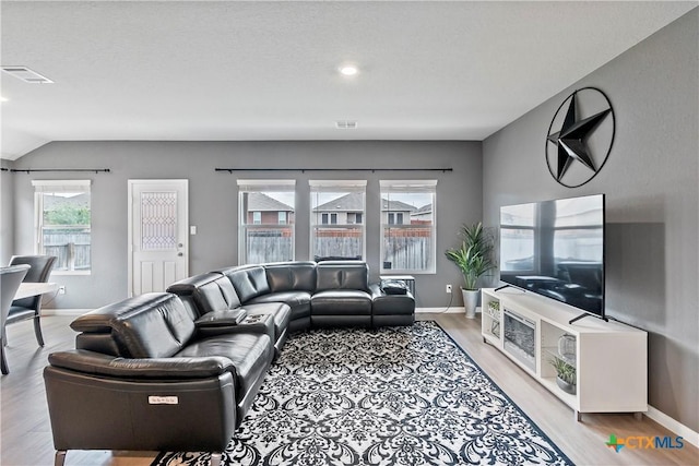 living room with visible vents, light wood-type flooring, and baseboards