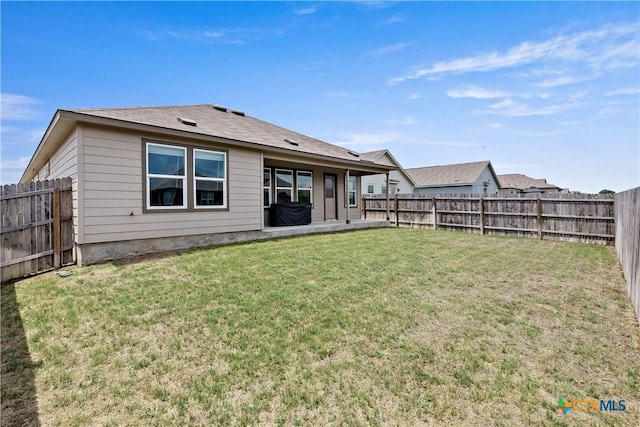 back of property with a lawn and a fenced backyard