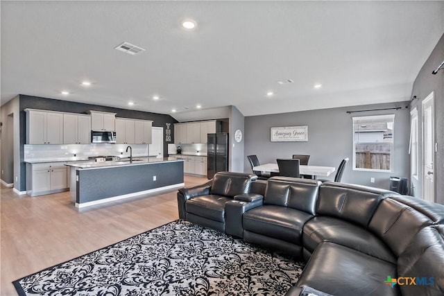 living room with visible vents, light wood-style floors, and recessed lighting
