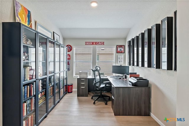 home office with wood finished floors, plenty of natural light, and baseboards
