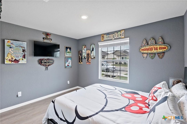 bedroom featuring wood finished floors, recessed lighting, and baseboards