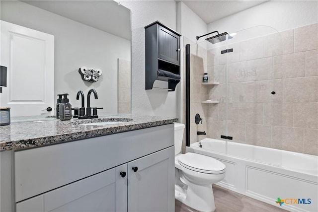 bathroom with wood finished floors, toilet, shower / tub combination, and vanity