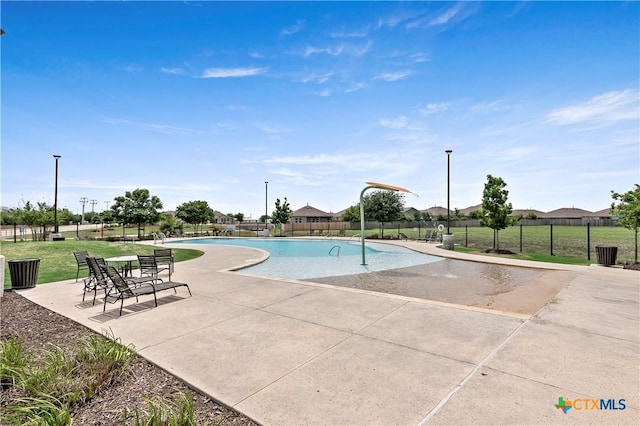 community pool featuring fence and a patio area