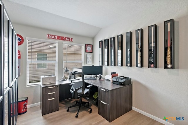 home office featuring baseboards, light wood-type flooring, and lofted ceiling