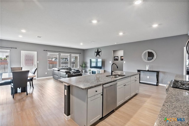 kitchen featuring recessed lighting, a sink, stainless steel appliances, and light wood-style floors