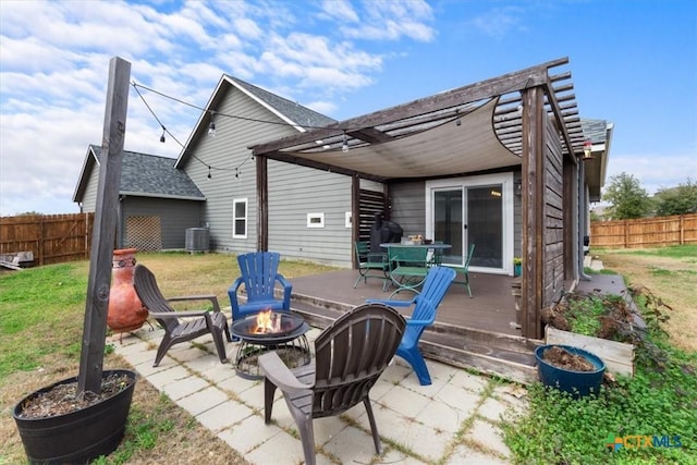 rear view of house with a wooden deck, a yard, cooling unit, and a fire pit