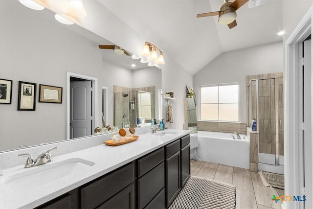 bathroom with vanity, vaulted ceiling, shower with separate bathtub, and ceiling fan