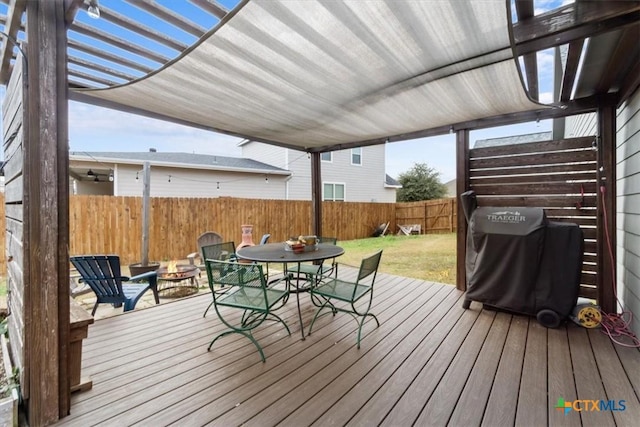 wooden terrace featuring area for grilling and a fire pit