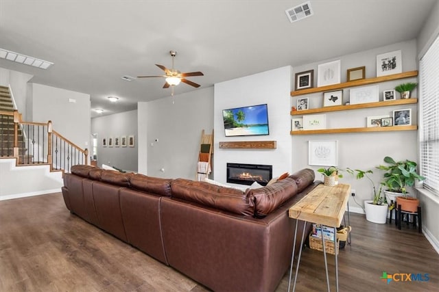 living room with ceiling fan and dark hardwood / wood-style flooring