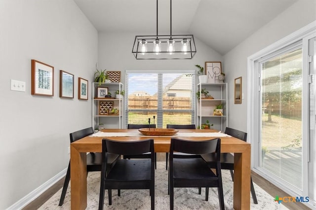 dining room featuring vaulted ceiling and light wood-type flooring