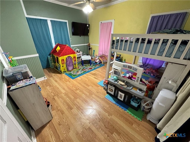 bedroom featuring hardwood / wood-style floors, ornamental molding, and ceiling fan