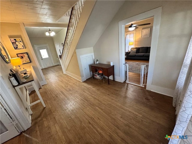 additional living space featuring vaulted ceiling, a wealth of natural light, hardwood / wood-style floors, and a notable chandelier