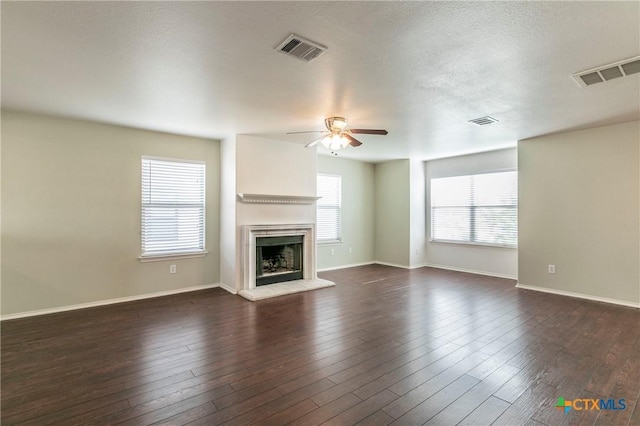 unfurnished living room featuring a textured ceiling, dark wood-type flooring, and ceiling fan