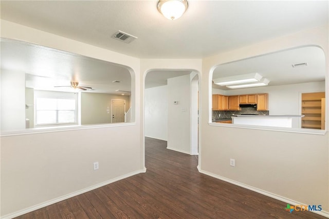 empty room featuring dark wood-type flooring and ceiling fan