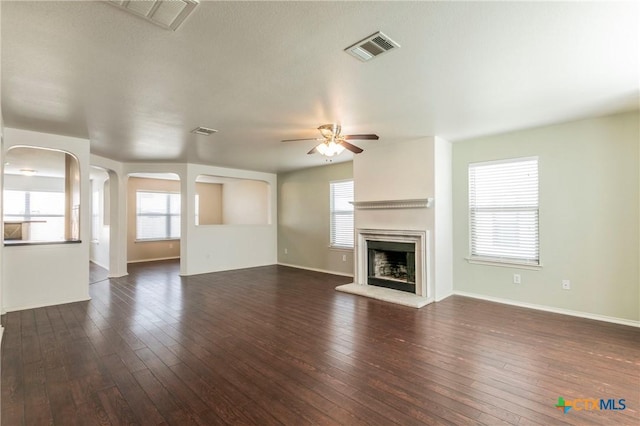 unfurnished living room featuring ceiling fan, dark hardwood / wood-style flooring, and a wealth of natural light