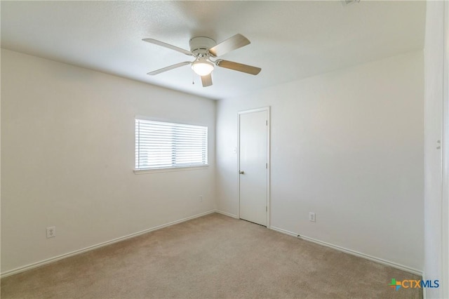 carpeted empty room featuring ceiling fan