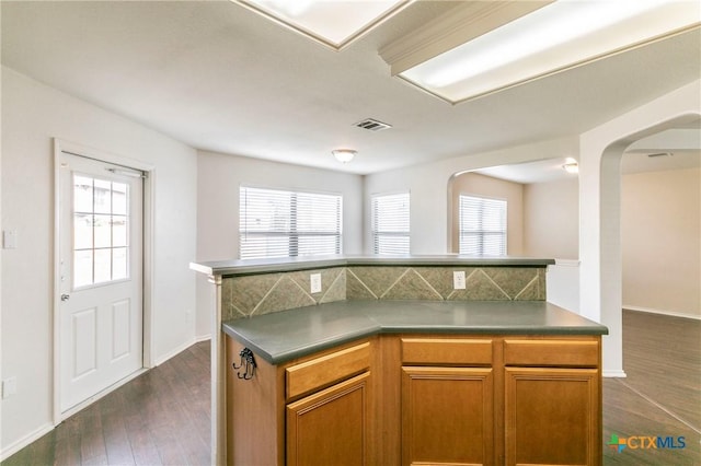 kitchen with dark hardwood / wood-style floors, a center island, and decorative backsplash